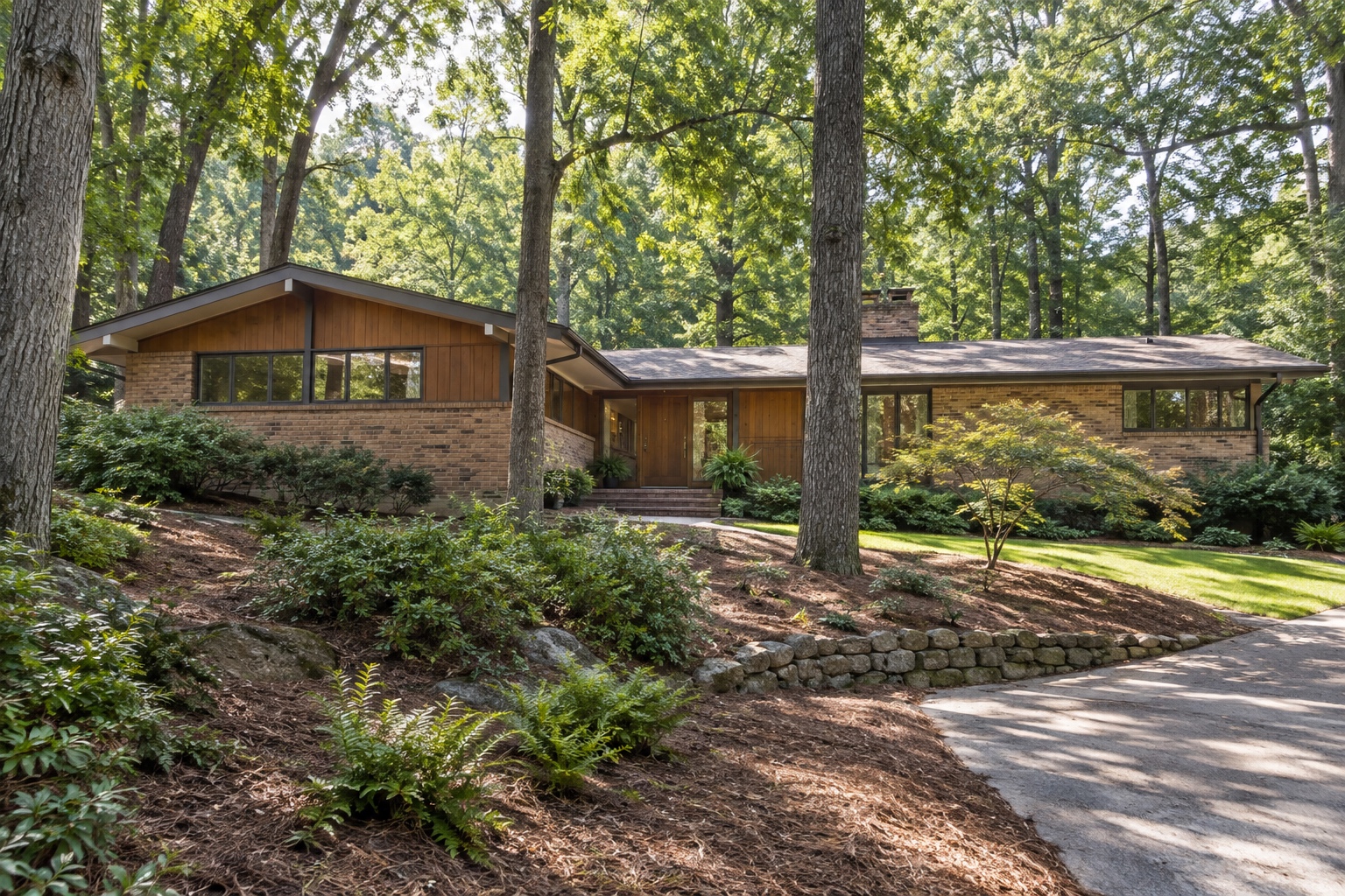 Mid-century ranch home under mature hardwood trees on a wooded lot in Roswell, Georgia