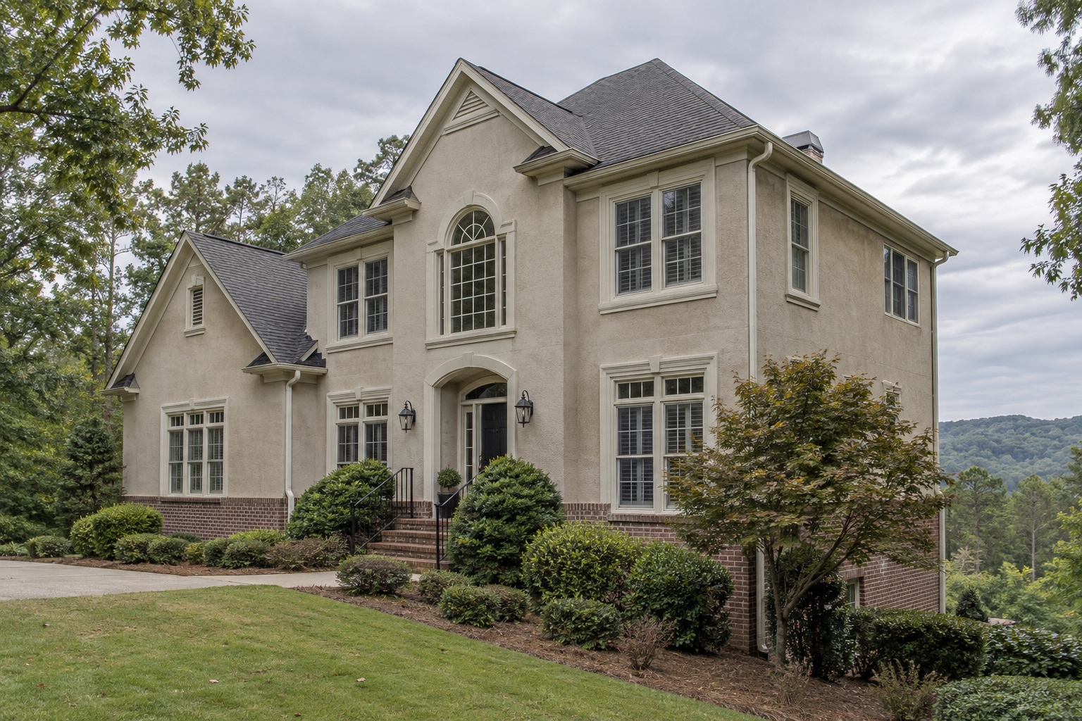 Two-story 1990s stucco home exterior with window trim and flashing details in North Fulton County, Georgia